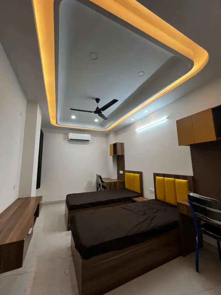 Furnished twin-sharing room with AC, study desks and warm lighting